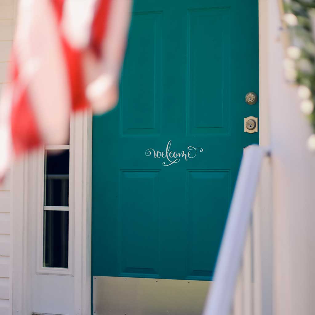 Welcome home painted on a blue door
